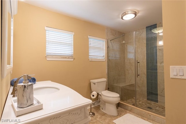 bathroom featuring a shower with shower door, sink, tile patterned floors, and toilet