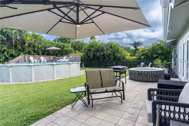 view of patio featuring a swimming pool with hot tub