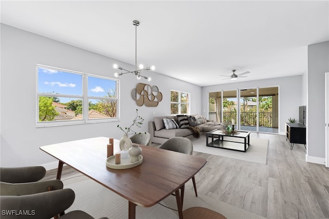 dining area featuring light wood-type flooring and ceiling fan with notable chandelier