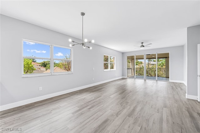 empty room featuring light hardwood / wood-style flooring and ceiling fan with notable chandelier