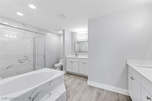 full bathroom with toilet, hardwood / wood-style floors, vanity, and independent shower and bath