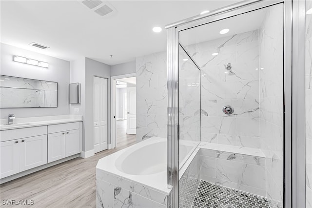 bathroom featuring vanity, separate shower and tub, and hardwood / wood-style floors