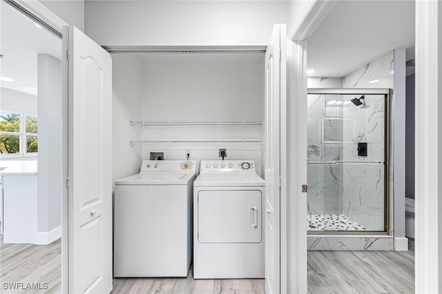 laundry room with light hardwood / wood-style flooring and washer and clothes dryer