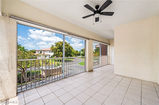 unfurnished sunroom with ceiling fan