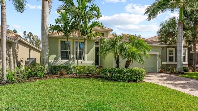 mediterranean / spanish-style home featuring a front lawn and a garage