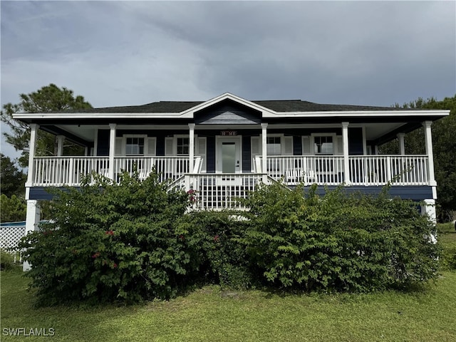 farmhouse featuring a front yard and covered porch