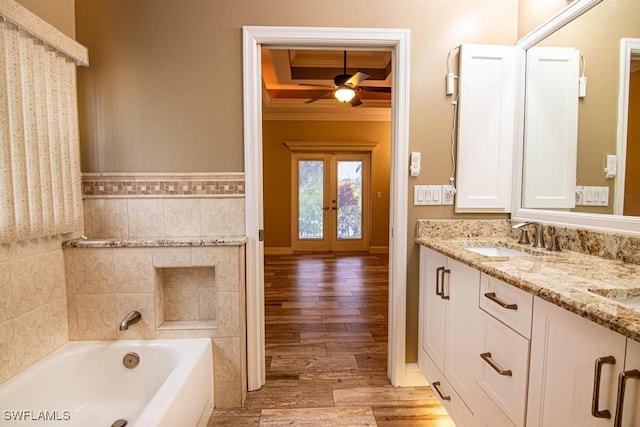 bathroom featuring vanity, hardwood / wood-style flooring, ceiling fan, ornamental molding, and a tub