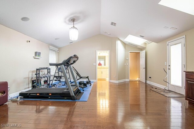 workout area featuring hardwood / wood-style floors and vaulted ceiling