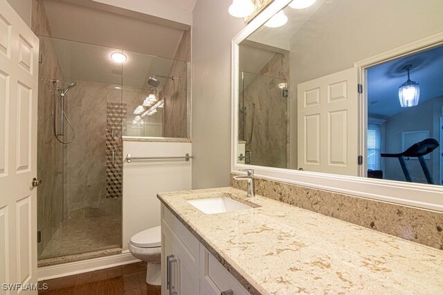 bathroom with hardwood / wood-style floors, vanity, toilet, and an enclosed shower