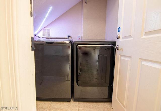 laundry room with washing machine and dryer and light tile patterned floors