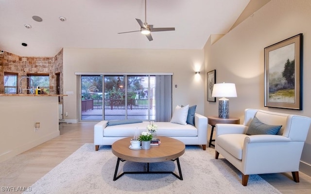 living room with ceiling fan, light hardwood / wood-style flooring, and vaulted ceiling