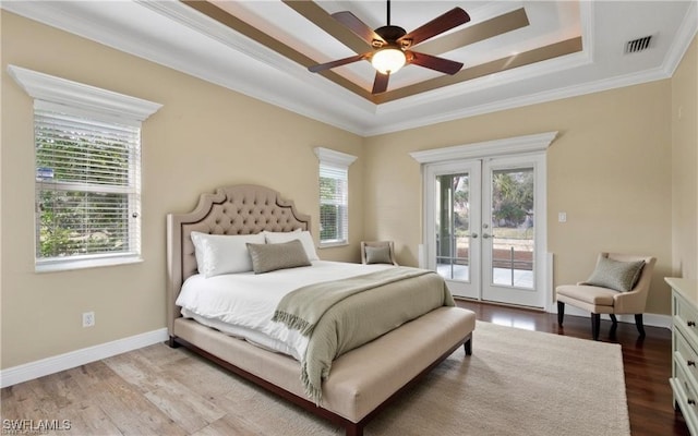 bedroom featuring a tray ceiling, access to exterior, ceiling fan, and french doors