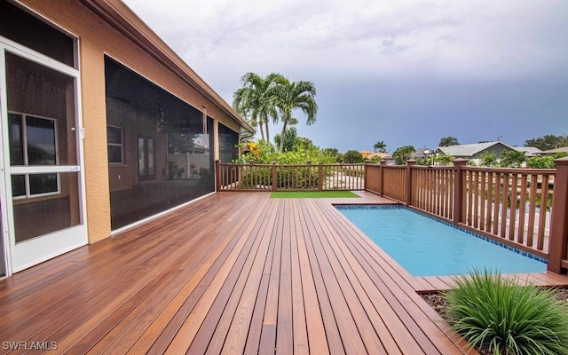 view of swimming pool featuring a sunroom and a deck