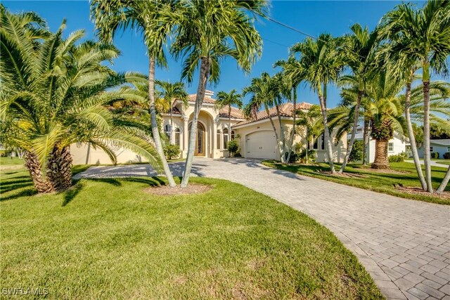 mediterranean / spanish-style house featuring a front yard and a garage