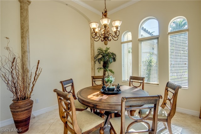 tiled dining space featuring an inviting chandelier, crown molding, and ornate columns