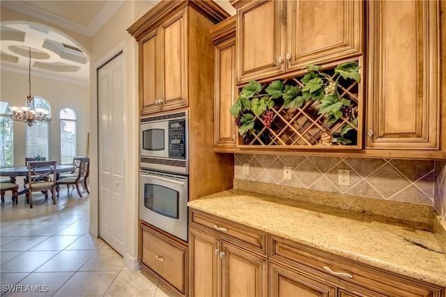 kitchen featuring a notable chandelier, crown molding, light stone countertops, hanging light fixtures, and appliances with stainless steel finishes