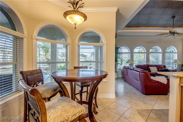 dining space with baseboards, light tile patterned flooring, a ceiling fan, and crown molding