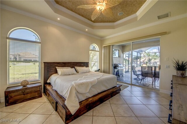 tiled bedroom featuring access to exterior, multiple windows, and a tray ceiling