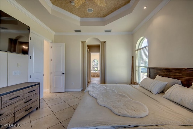 bedroom with a tray ceiling, light tile patterned flooring, crown molding, and arched walkways