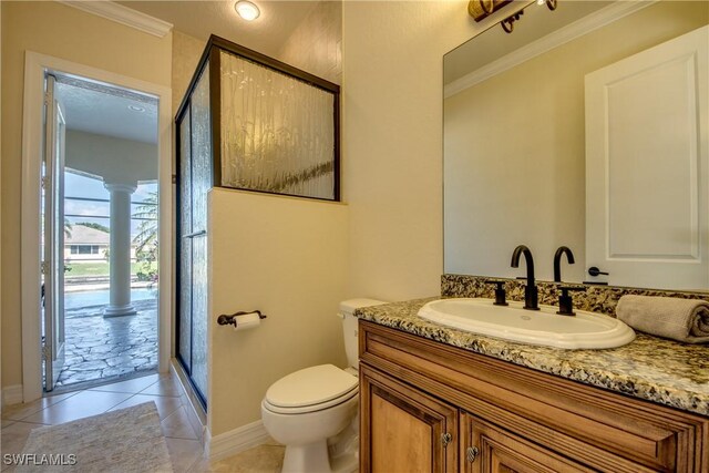 bathroom featuring tile patterned floors, vanity, toilet, a shower with shower door, and ornamental molding