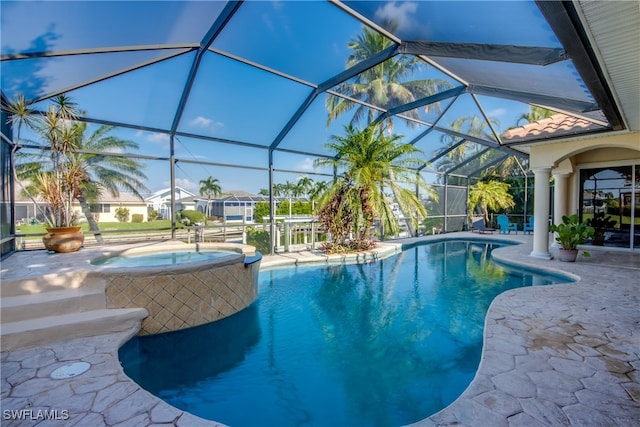 view of pool with a lanai, a patio area, and an in ground hot tub