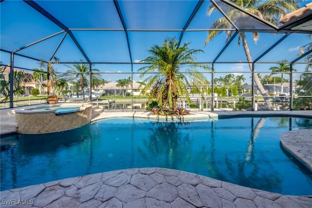 view of swimming pool with a lanai, a patio area, and an in ground hot tub