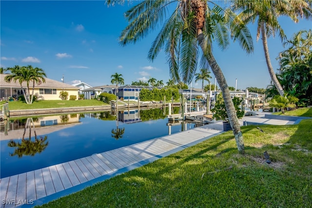 view of dock with a water view and a lawn