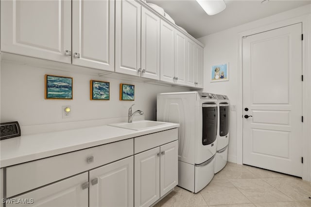 laundry area with cabinets, light tile patterned flooring, sink, and washer and clothes dryer