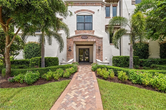 view of exterior entry with french doors and stucco siding