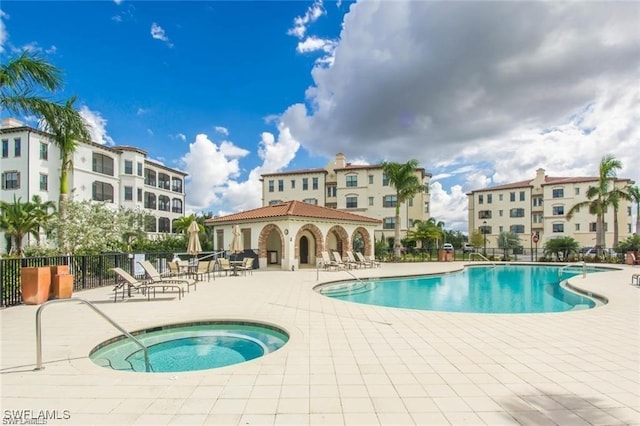 pool featuring a patio area, fence, and a hot tub