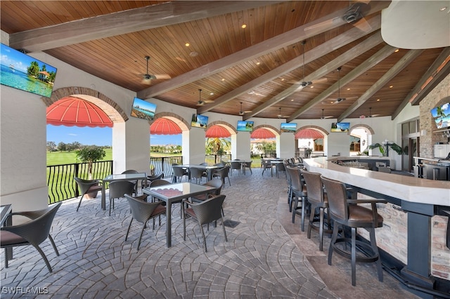 view of patio featuring outdoor wet bar, ceiling fan, a gazebo, and fence