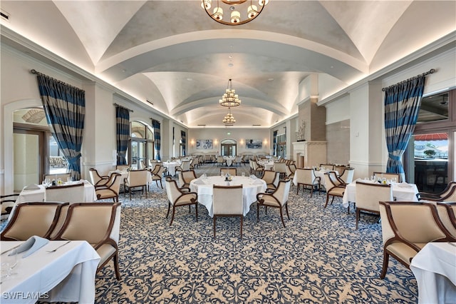 dining room with a notable chandelier, a healthy amount of sunlight, and vaulted ceiling