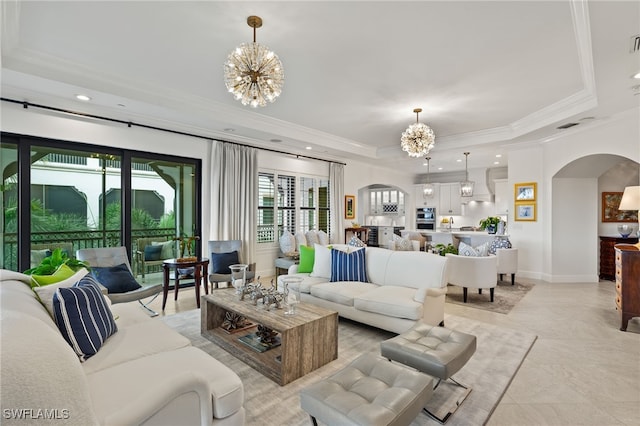 living room with a chandelier, crown molding, and a raised ceiling