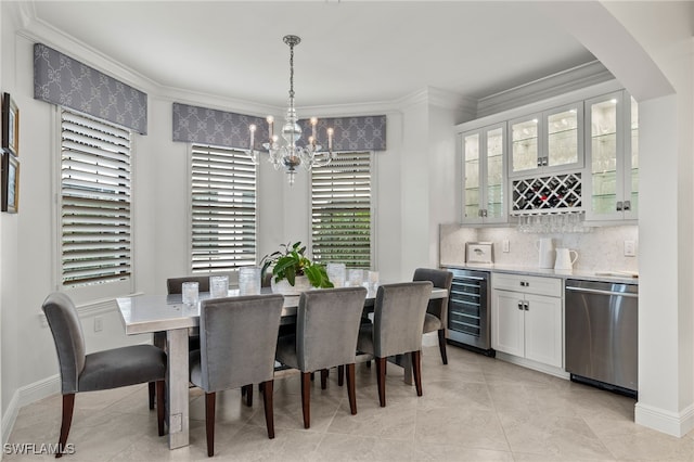 dining space with beverage cooler, ornamental molding, indoor bar, and a notable chandelier