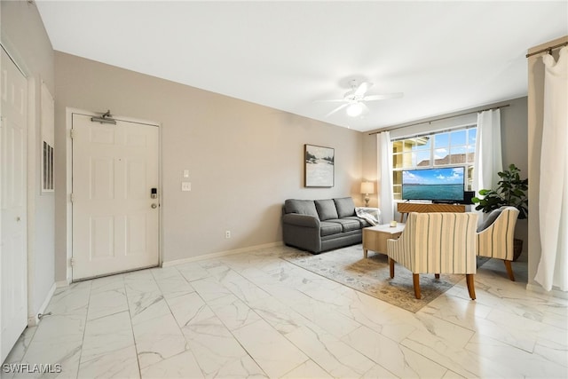 living room with marble finish floor, ceiling fan, and baseboards