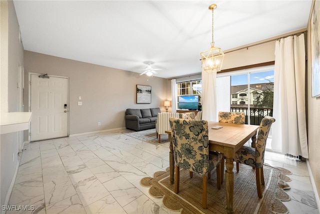 dining room featuring marble finish floor, baseboards, and ceiling fan with notable chandelier