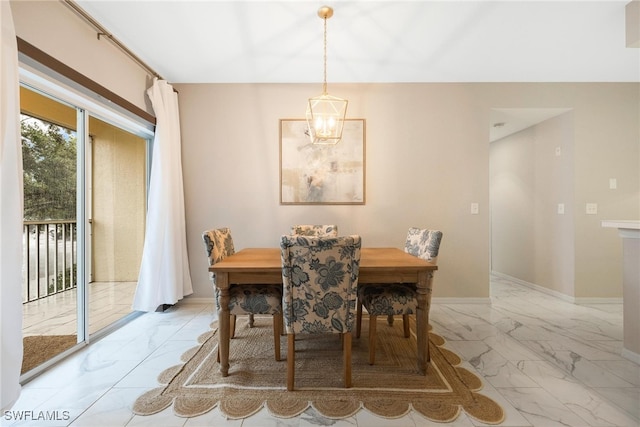 dining room featuring a notable chandelier, marble finish floor, and baseboards