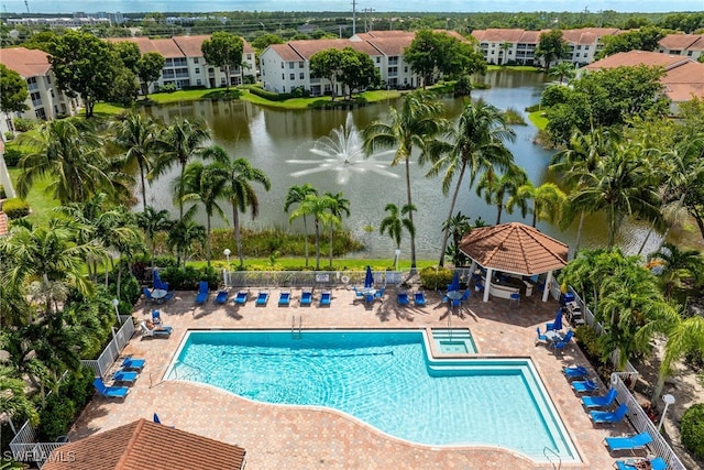 pool with a patio area, a water view, fence, and a gazebo