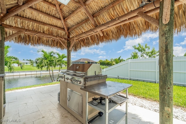 view of patio featuring area for grilling, grilling area, a gazebo, and a water view