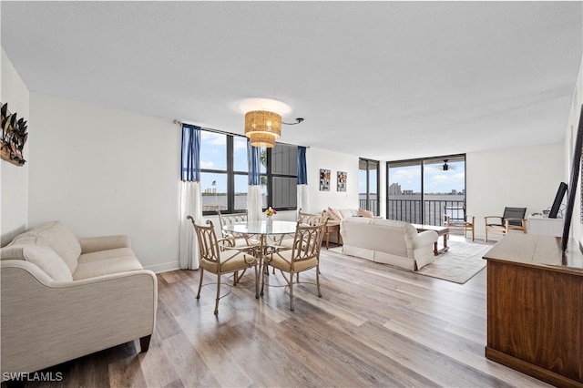 dining space featuring a wealth of natural light, light hardwood / wood-style flooring, and a wall of windows