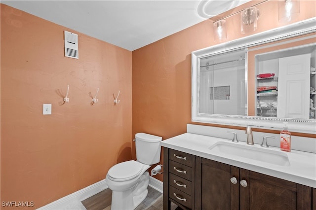 bathroom with vanity, toilet, and wood-type flooring