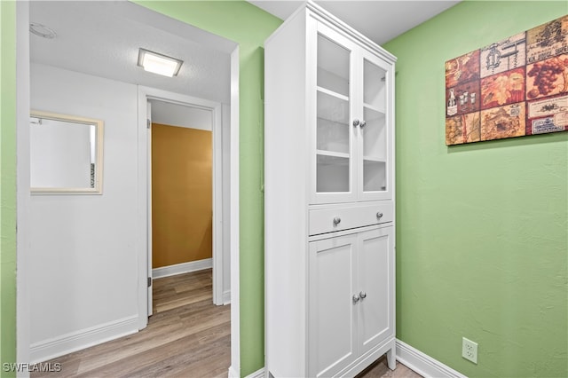 hallway featuring wood-type flooring and a textured ceiling