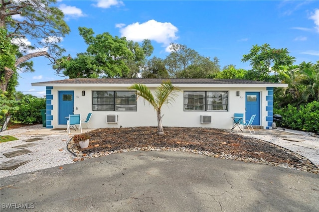 view of front of property with an AC wall unit