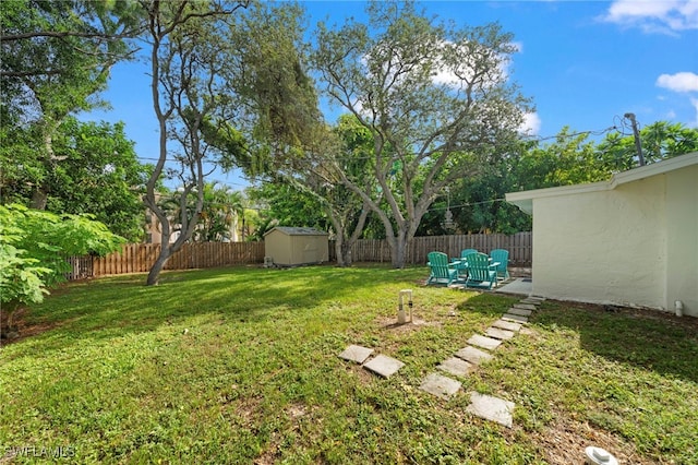 view of yard with an outbuilding, a shed, a patio area, and a fenced backyard