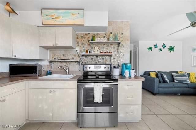 kitchen featuring stainless steel appliances, tasteful backsplash, a ceiling fan, light tile patterned flooring, and a sink