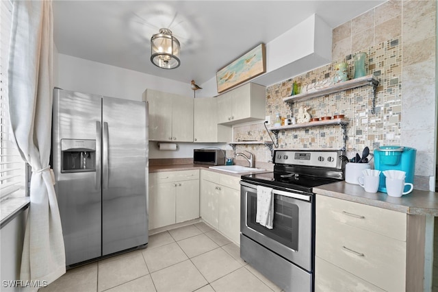 kitchen with appliances with stainless steel finishes, a sink, open shelves, backsplash, and light tile patterned flooring