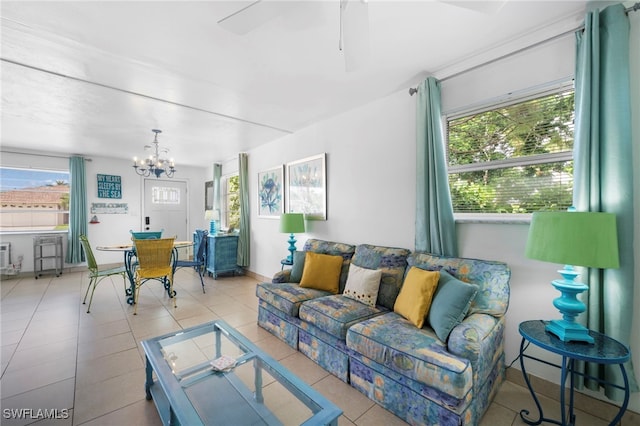 living room featuring ceiling fan with notable chandelier and light tile patterned floors