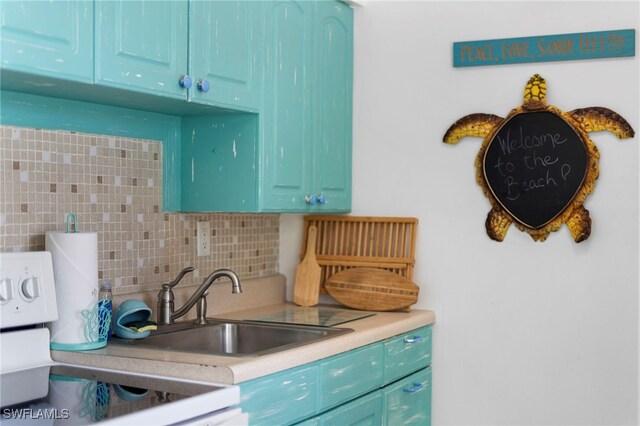 kitchen with sink, tasteful backsplash, blue cabinets, and range