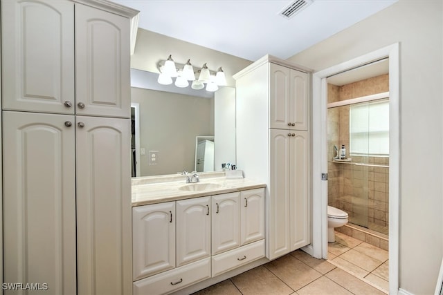 bathroom featuring toilet, an enclosed shower, tile patterned flooring, and vanity