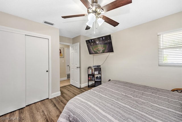 bedroom featuring ceiling fan, a closet, and hardwood / wood-style flooring